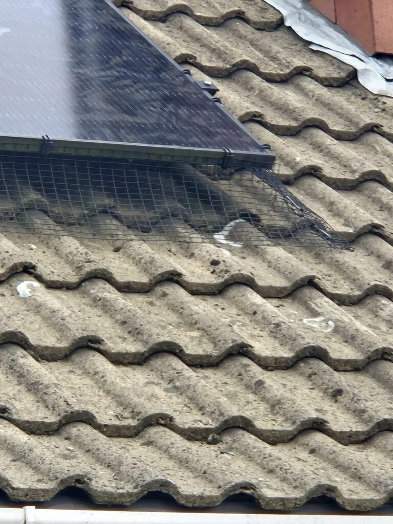 Bird mesh professionally installed around solar panels in Leeds to stop pigeons nesting beneath the solar panel system.