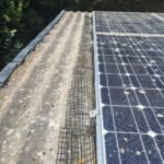 Close-up side view of solar pigeon proofing mesh and clips