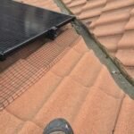 UV-rated Solar Fast Fix clips securing black PVC-coated pigeon-proofing mesh to solar panel frames.
